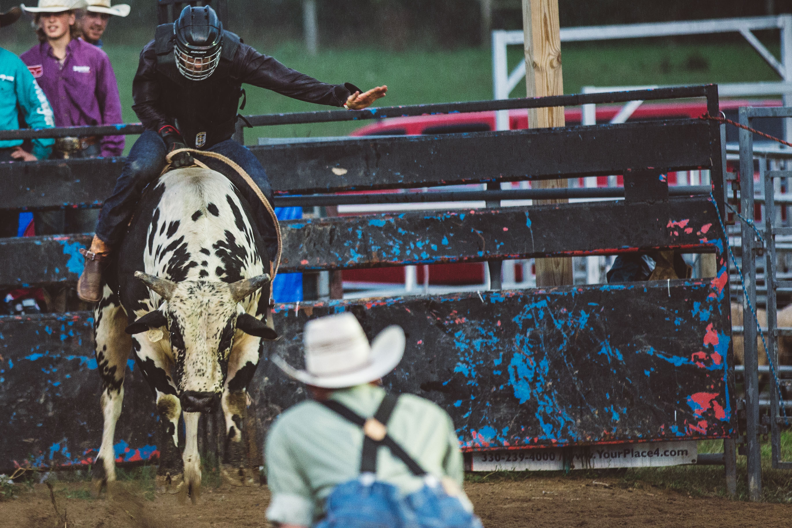 Men watch man ride bull
