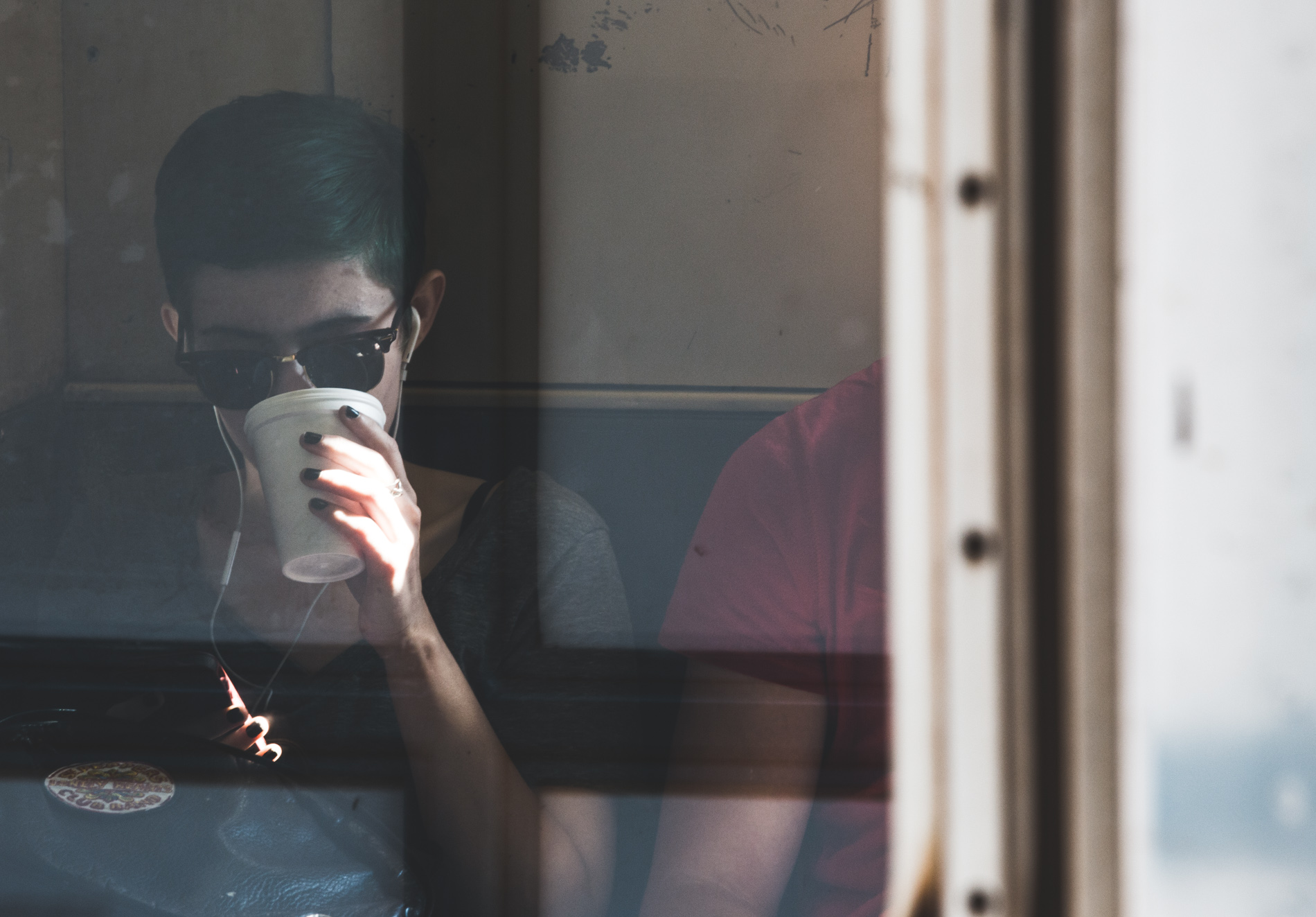 girl drinking coffee on subway