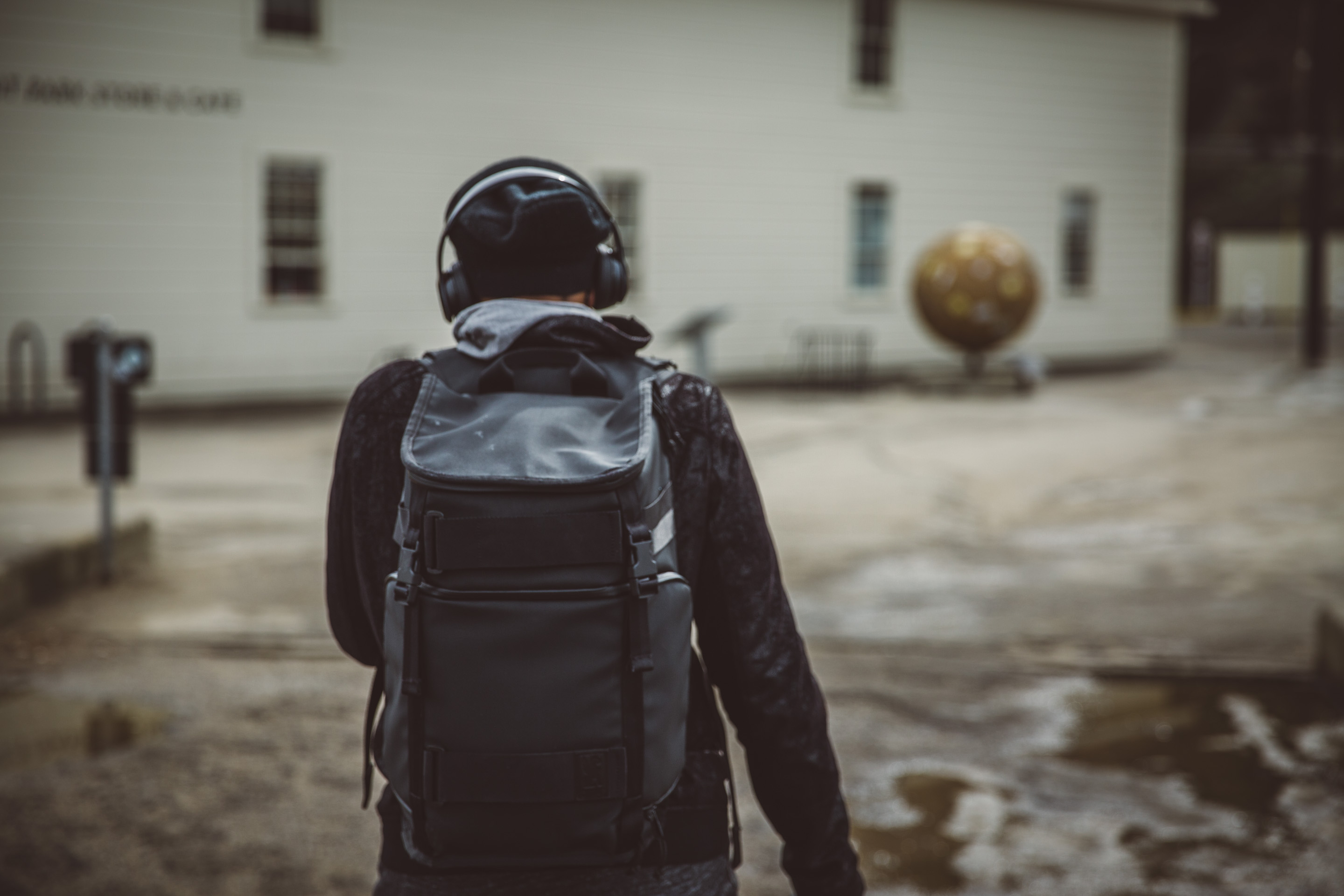 guy walking with headphones and backpack