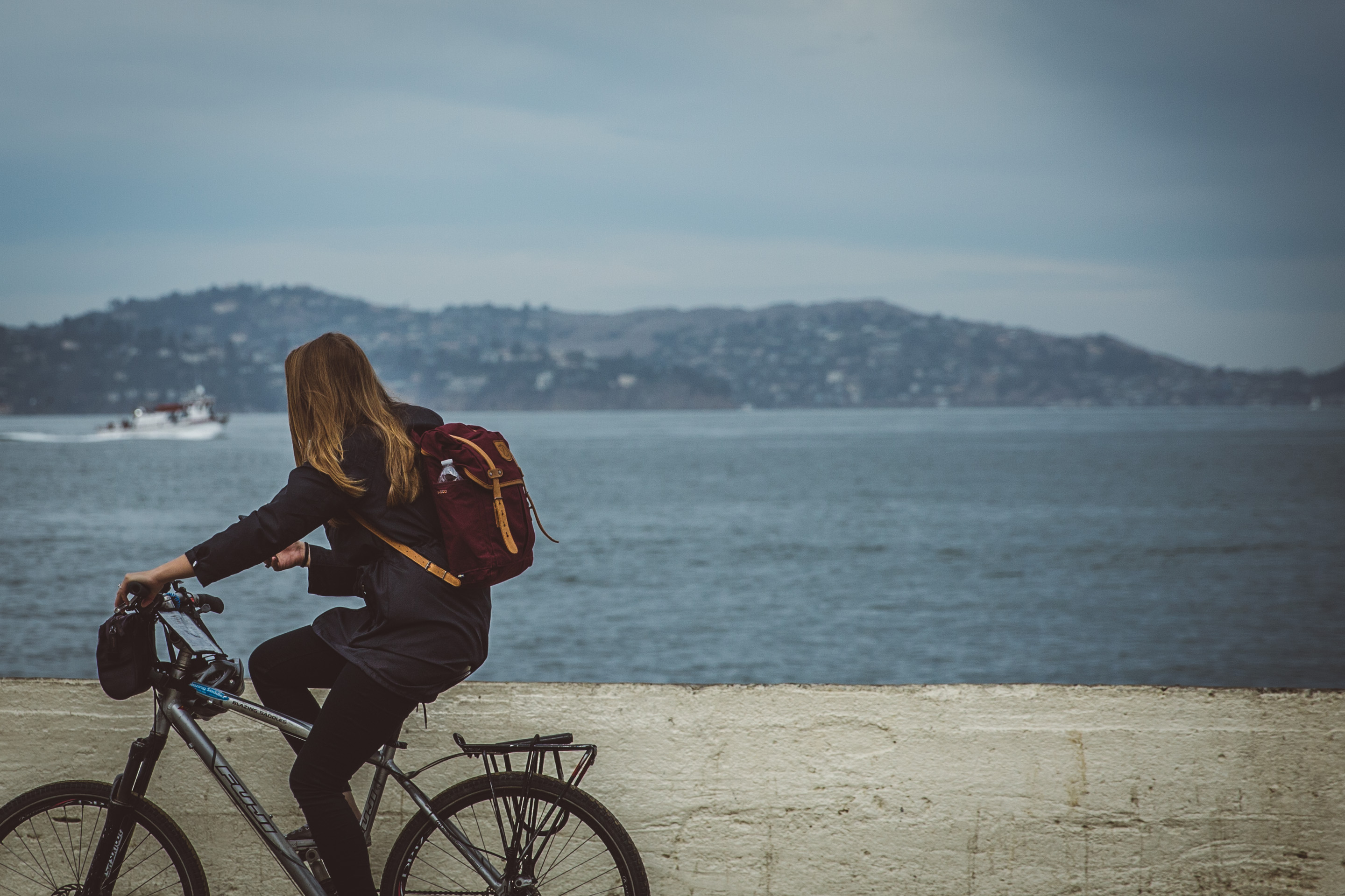 girl riding bike along the ocean