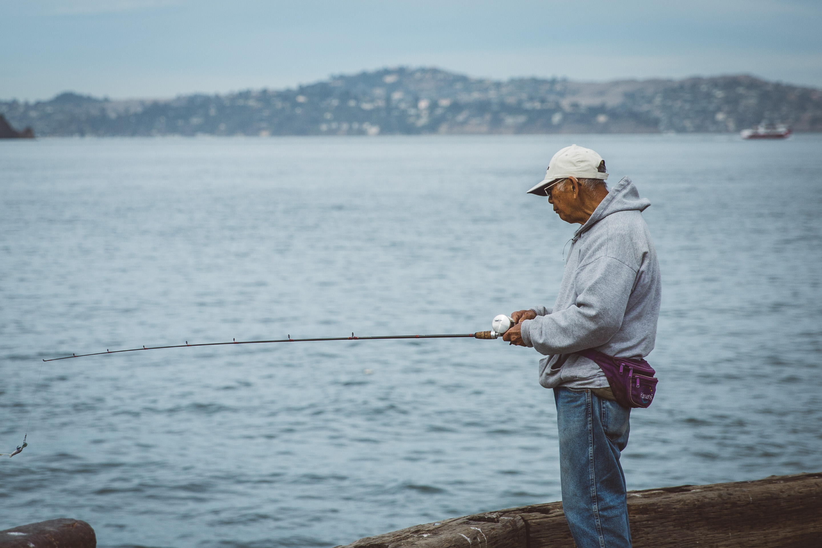 man with fishing pole on pier